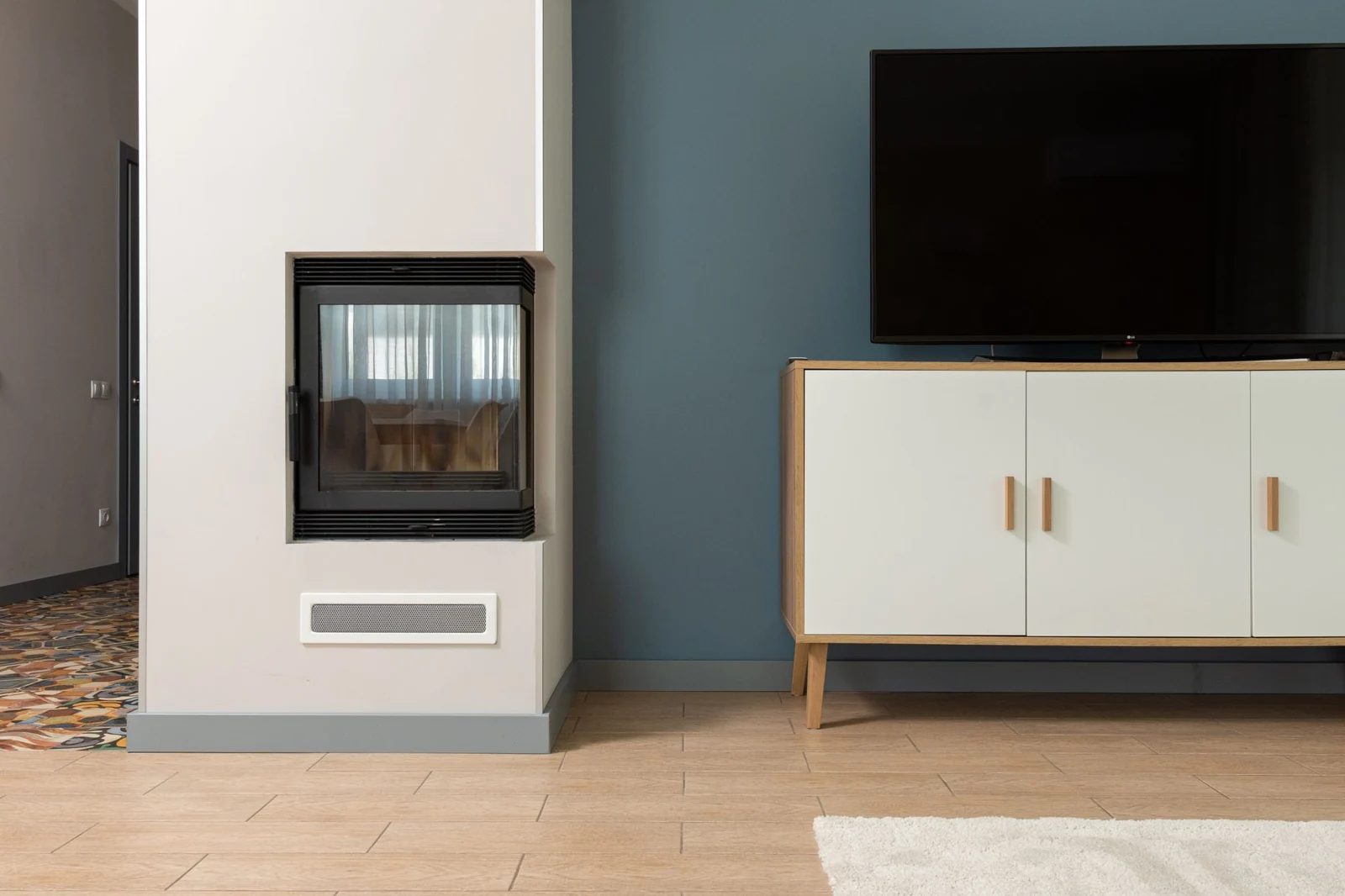 Compact enclosed fireplace built into a grey wall